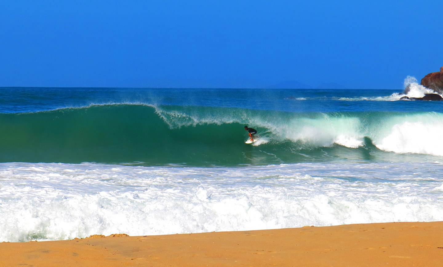 Surfista pegando uma onda em Ubatuba
